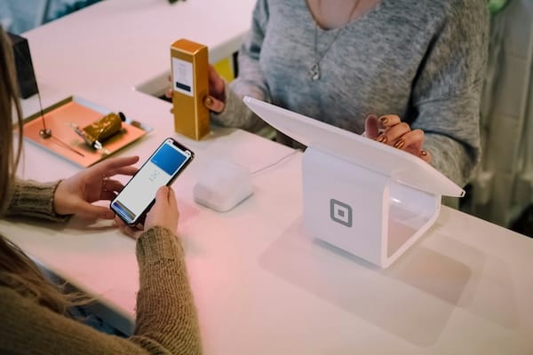 Stock photo of someone checking out at a store using a digital wallet to pay