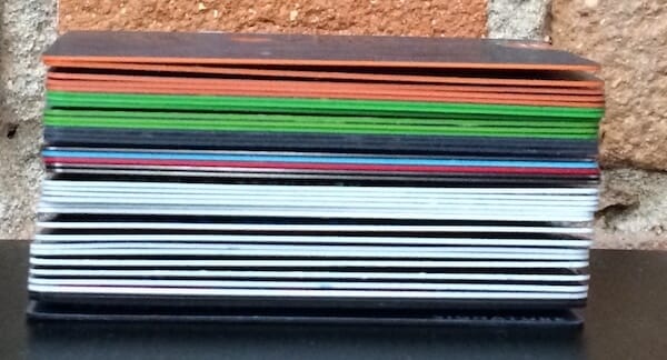 A tall stack of credit cards using different colored plastic.