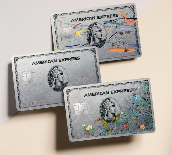 Three silver American Express cards, two with art designs on them.