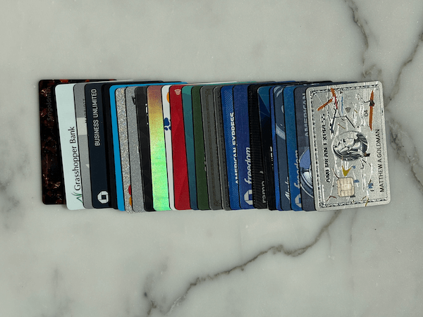 A row of credit cards spread out so you can see a little of each on a white and gray marble background.