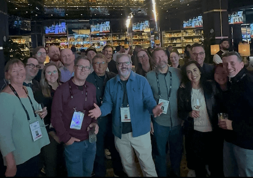 Group photo of people at a conference with a bar in the background.