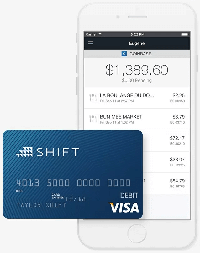 Screenshot of the Coinbase app on a white iPhone circa 2015. In front of the phone image is a blue credit card with the Shift logo in the top left, Debit Visa in the bottom right, and embossed card numbers, name, and expiration date in the middle.