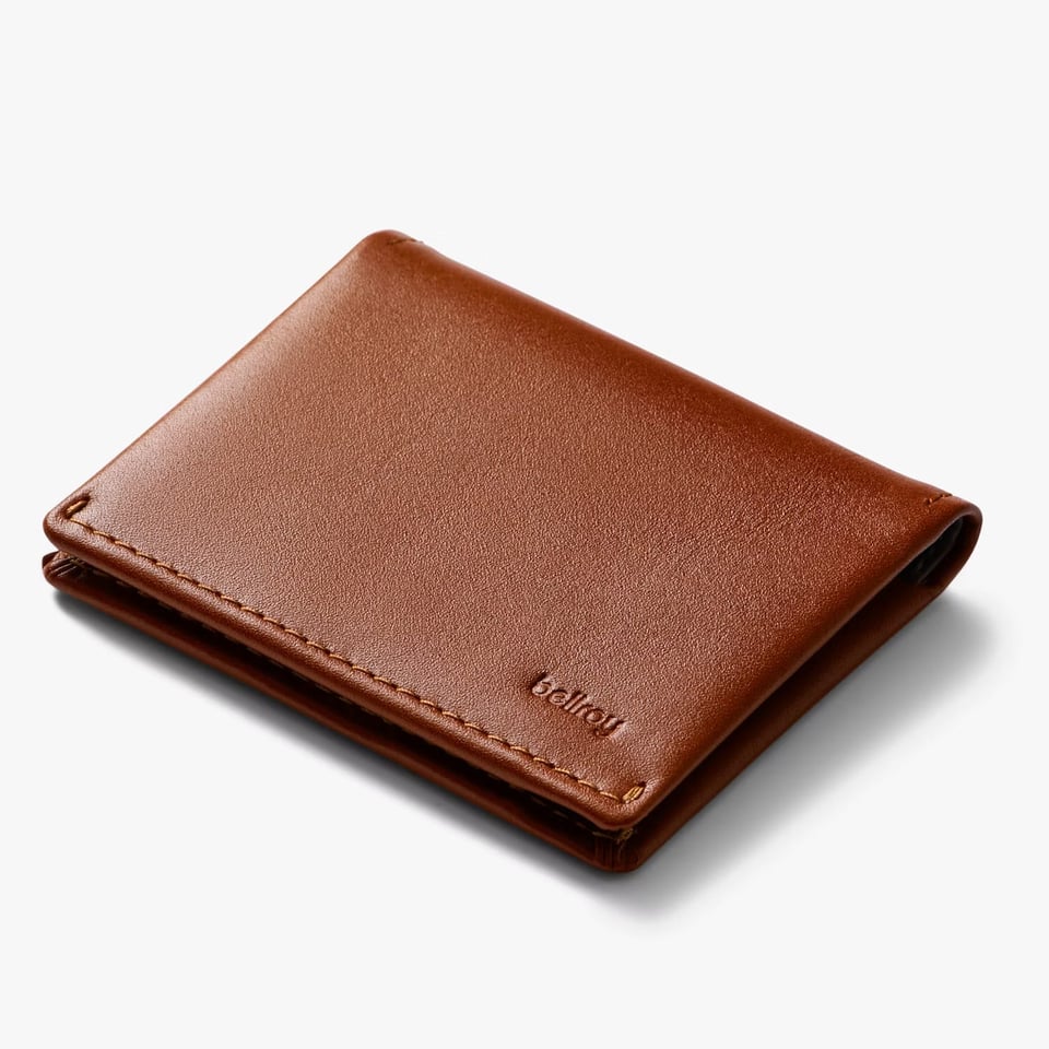 Image of a sleek, minimalist brown leather wallet with visible stitching along the edges. The wallet features the ‘Bellroy’ logo embossed in the lower-right corner, highlighting its premium craftsmanship.