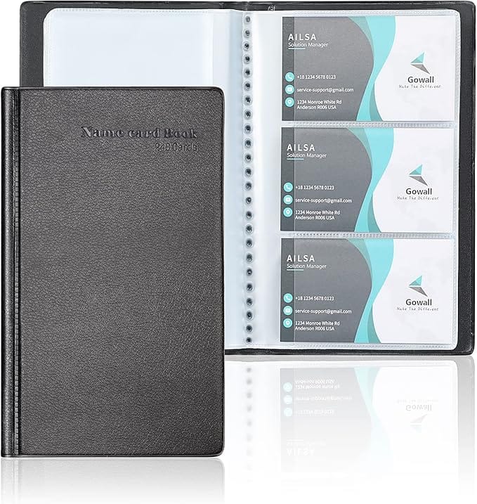 Image of a black leather-bound name card book with ‘Name card Book 240 Cards’ embossed on the cover. The book is open, displaying clear plastic sleeves holding business cards.